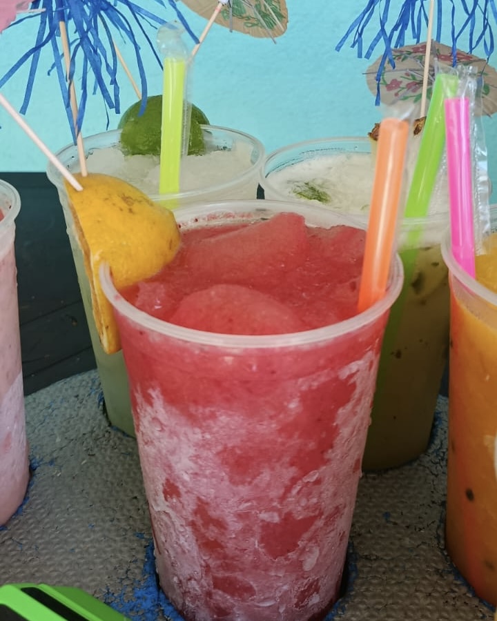 Caipirinha de morango gelada com sombrinhas coloridas