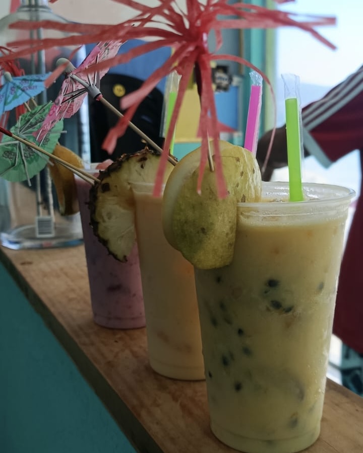 Caipirinhas cremosas de frutas enfileiradas no balcão